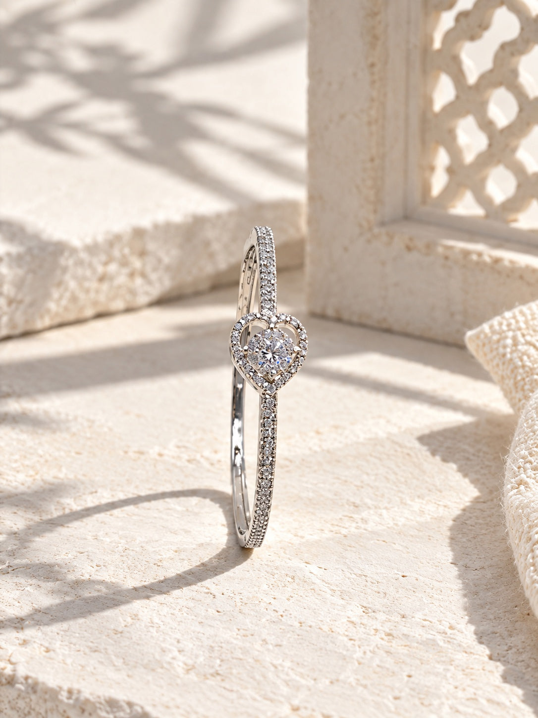 BR26N20033 silver heart bangle on ivory stone with hard sunlight