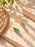 Green teardrop earrings on travertine