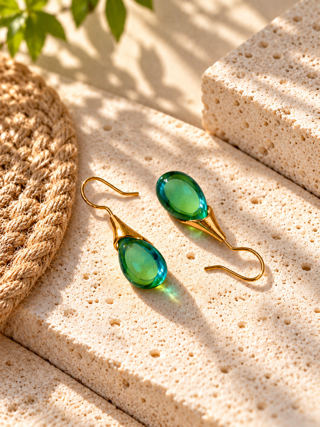 Green teardrop earrings on travertine