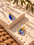 Blue resin earrings on travertine steps