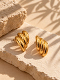 Gold earrings alternate angle on beige stone