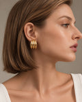 Model wearing gold earrings close-up profile