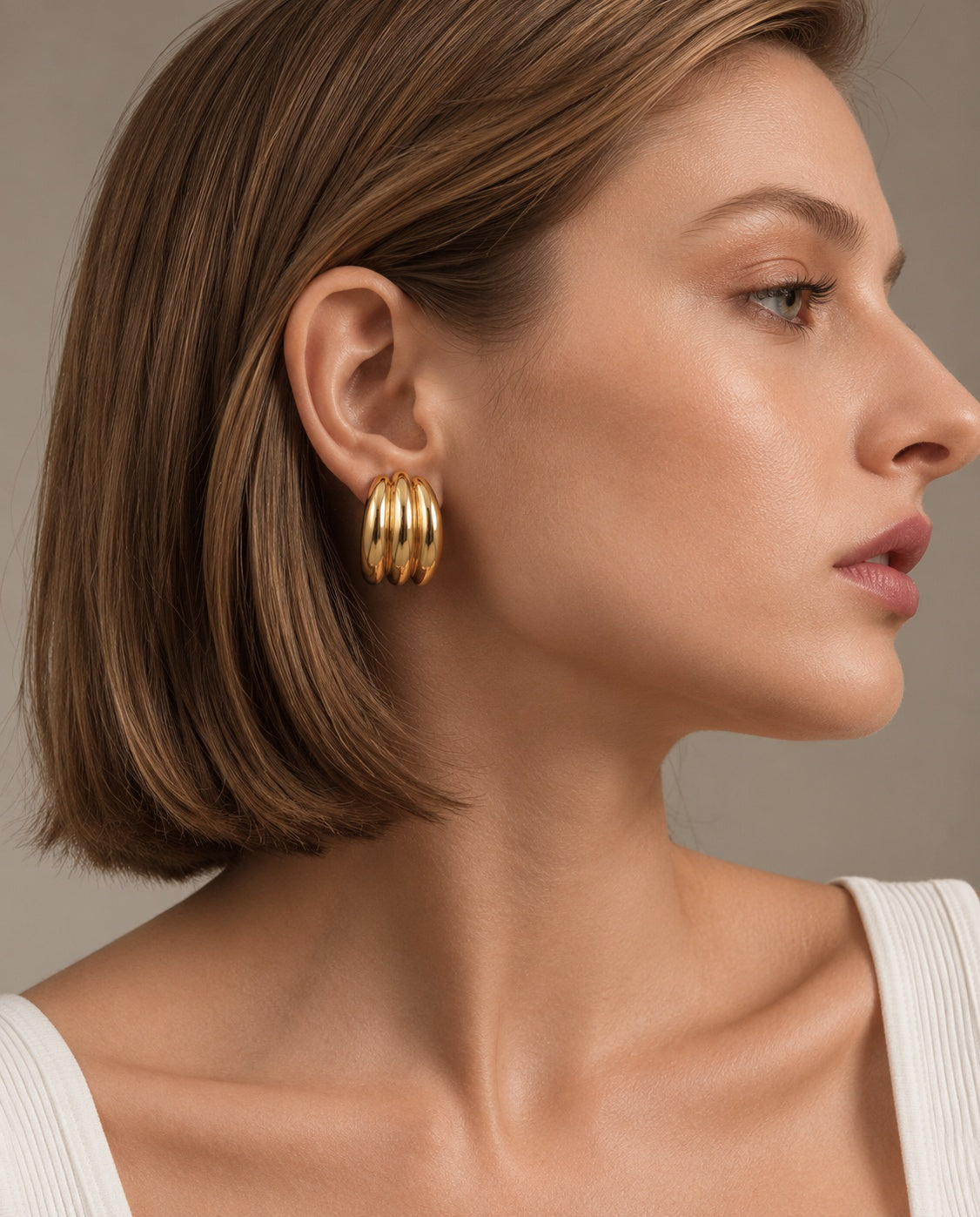 Model wearing gold earrings close-up profile