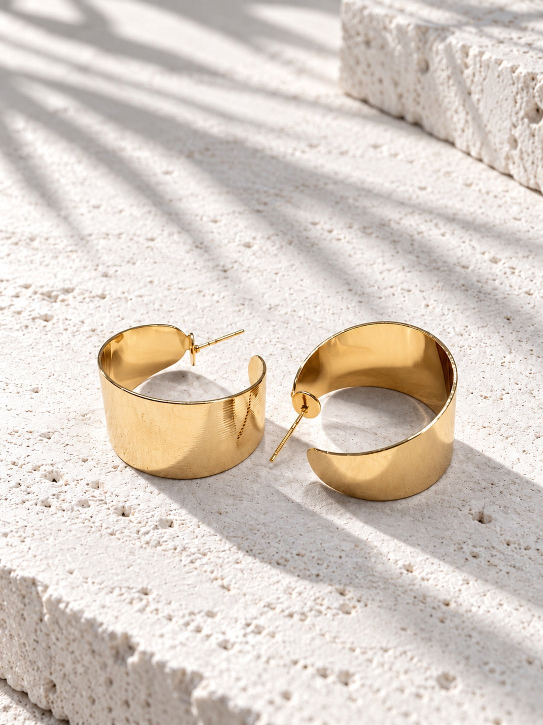 Niska gold-tone sculptural hoop earring worn by model