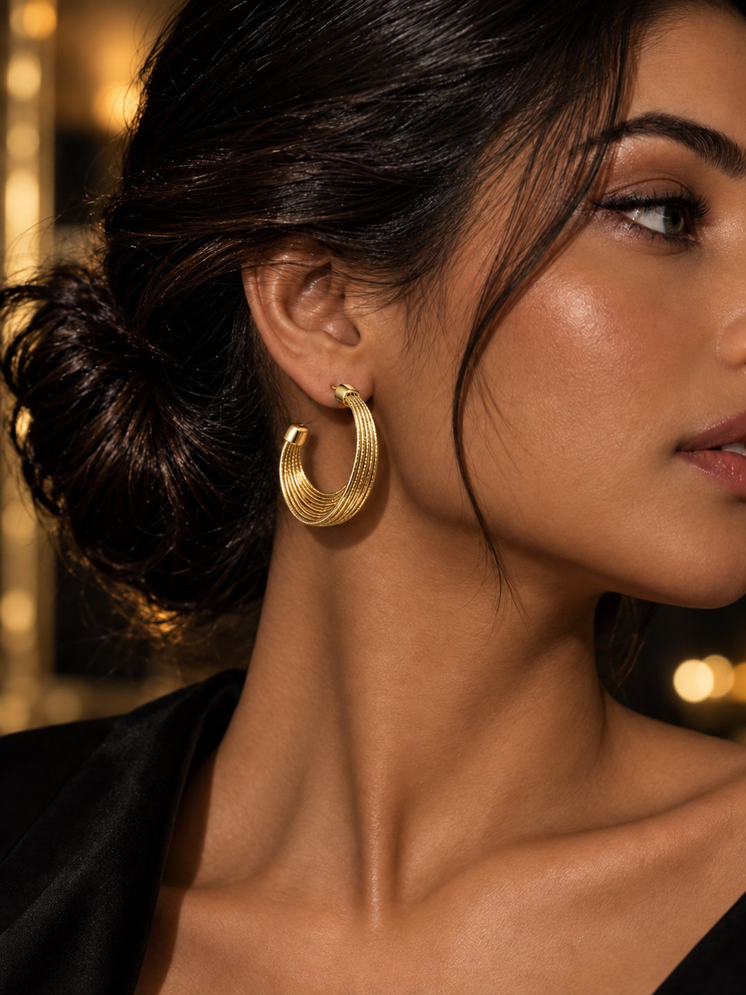 Niska gold-tone textured multi-band hoop earring worn by model