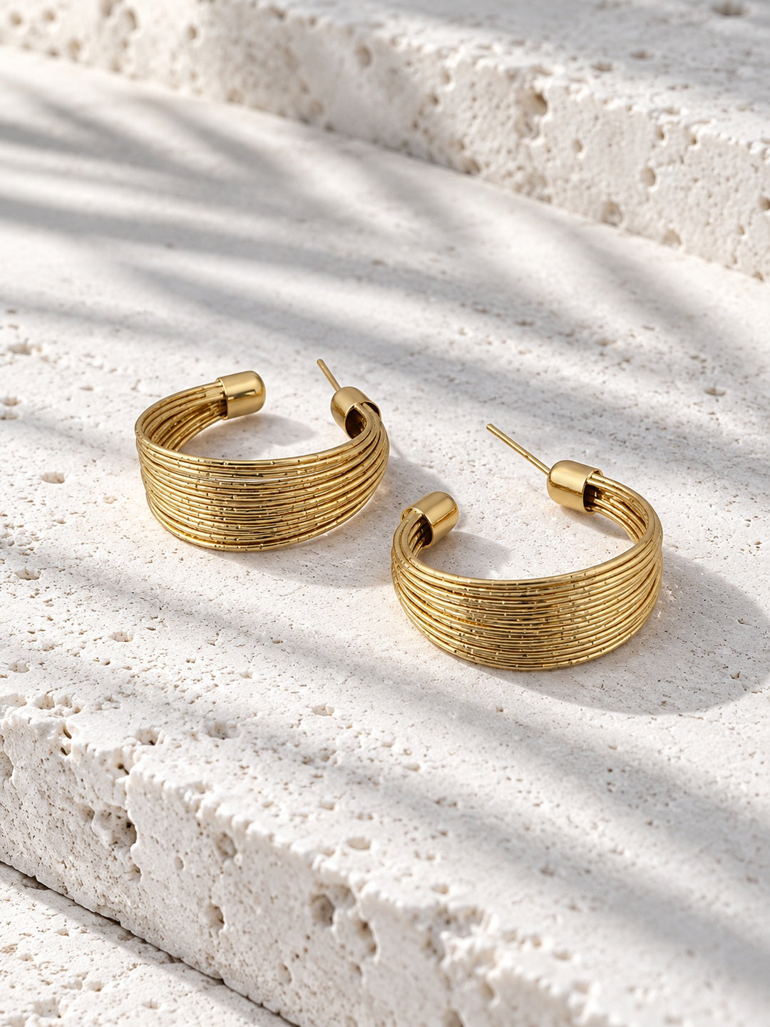 Niska gold-tone textured multi-band hoop earring worn by model