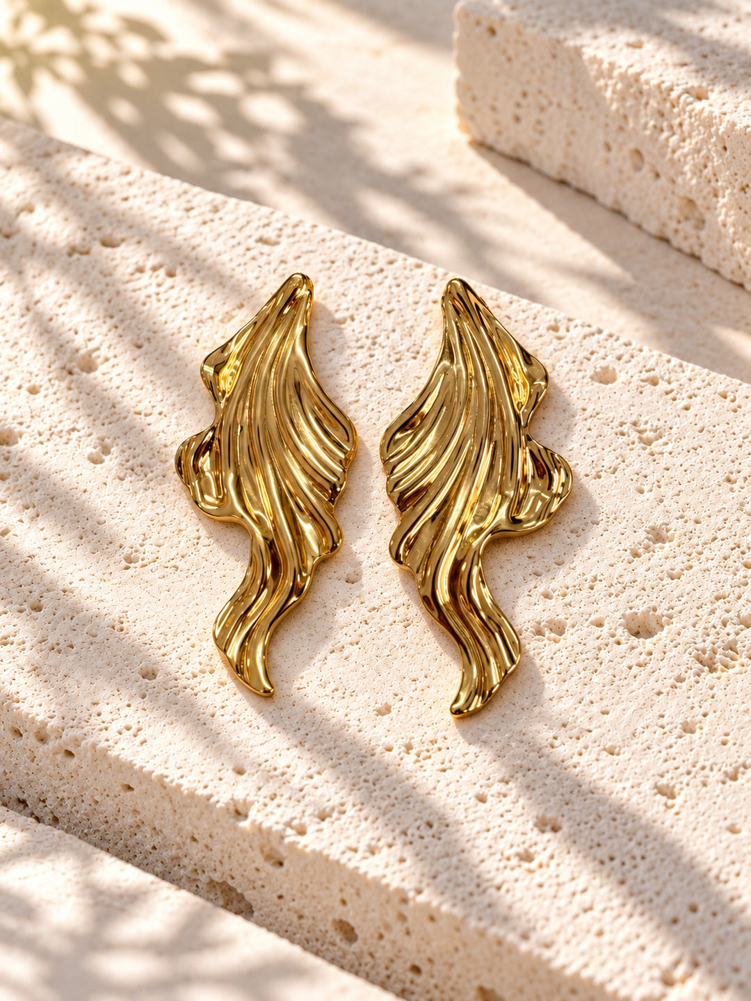 Niska gold-tone sculpted leaf Resin earrings on white travertine – view 4