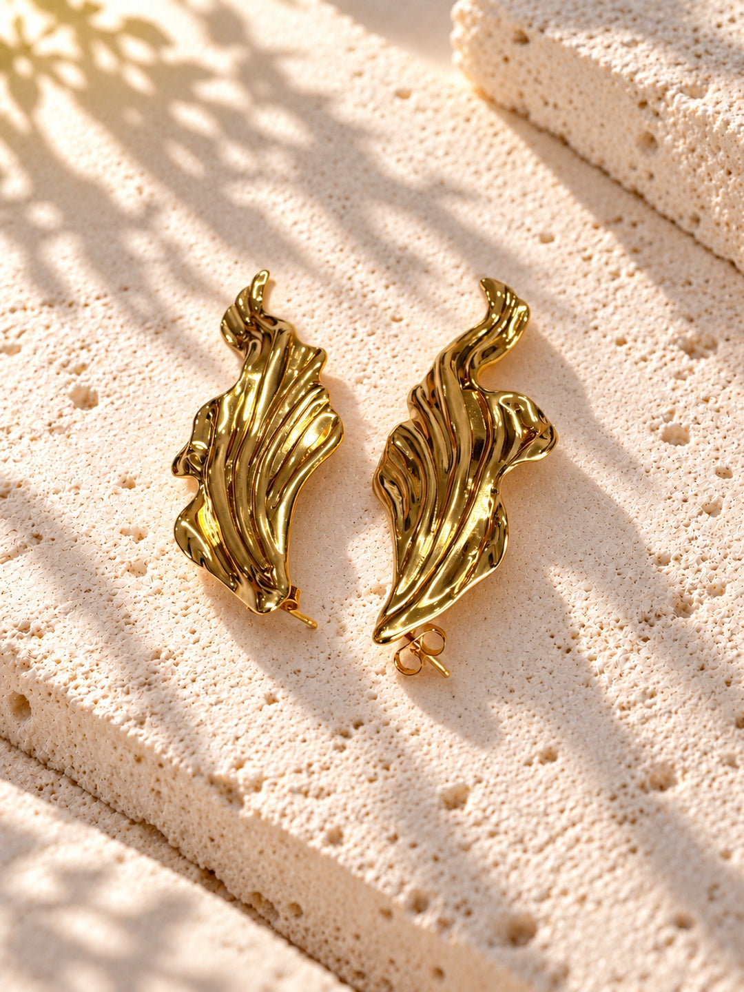 Niska gold-tone sculpted leaf Resin earrings on white travertine – view 6