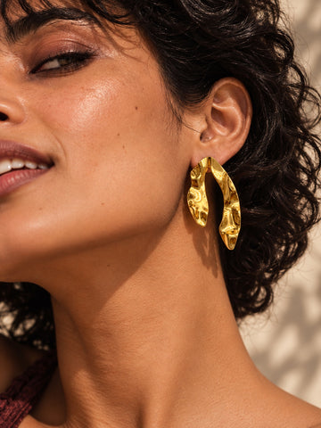 Niska gold-tone sculpted resin statement earring worn by a model