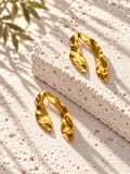 Niska gold-tone sculpted resin statement earrings on white travertine – view 3