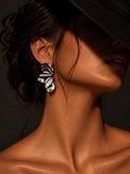 Model wearing Niska silver-tone sculptural wave statement earring