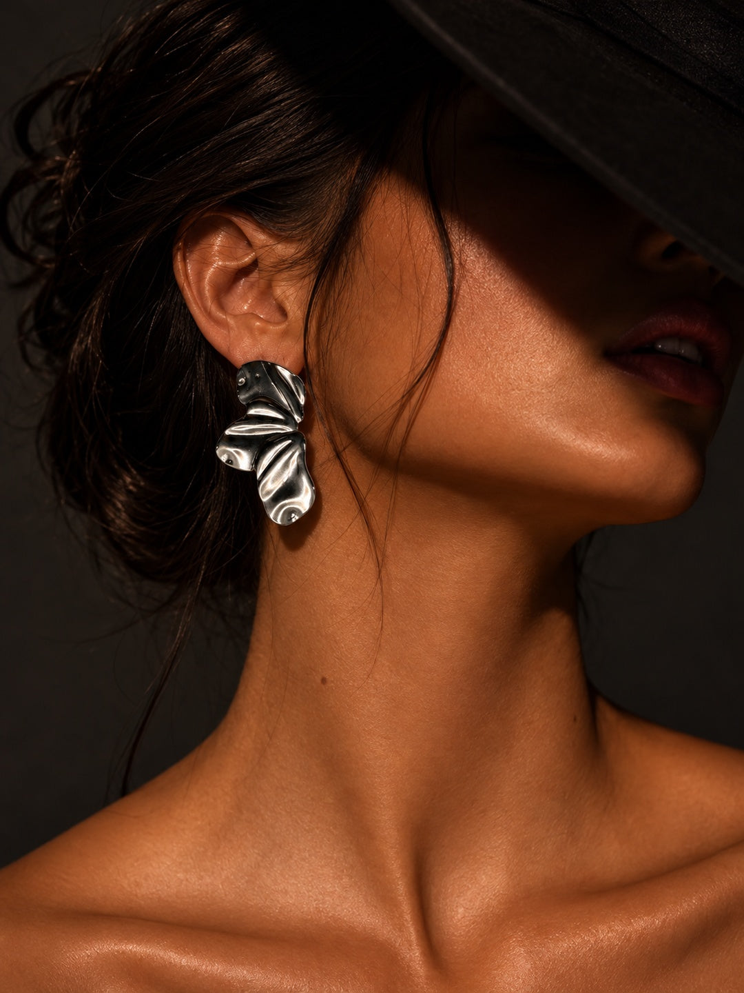 Model wearing Niska silver-tone sculptural wave statement earring