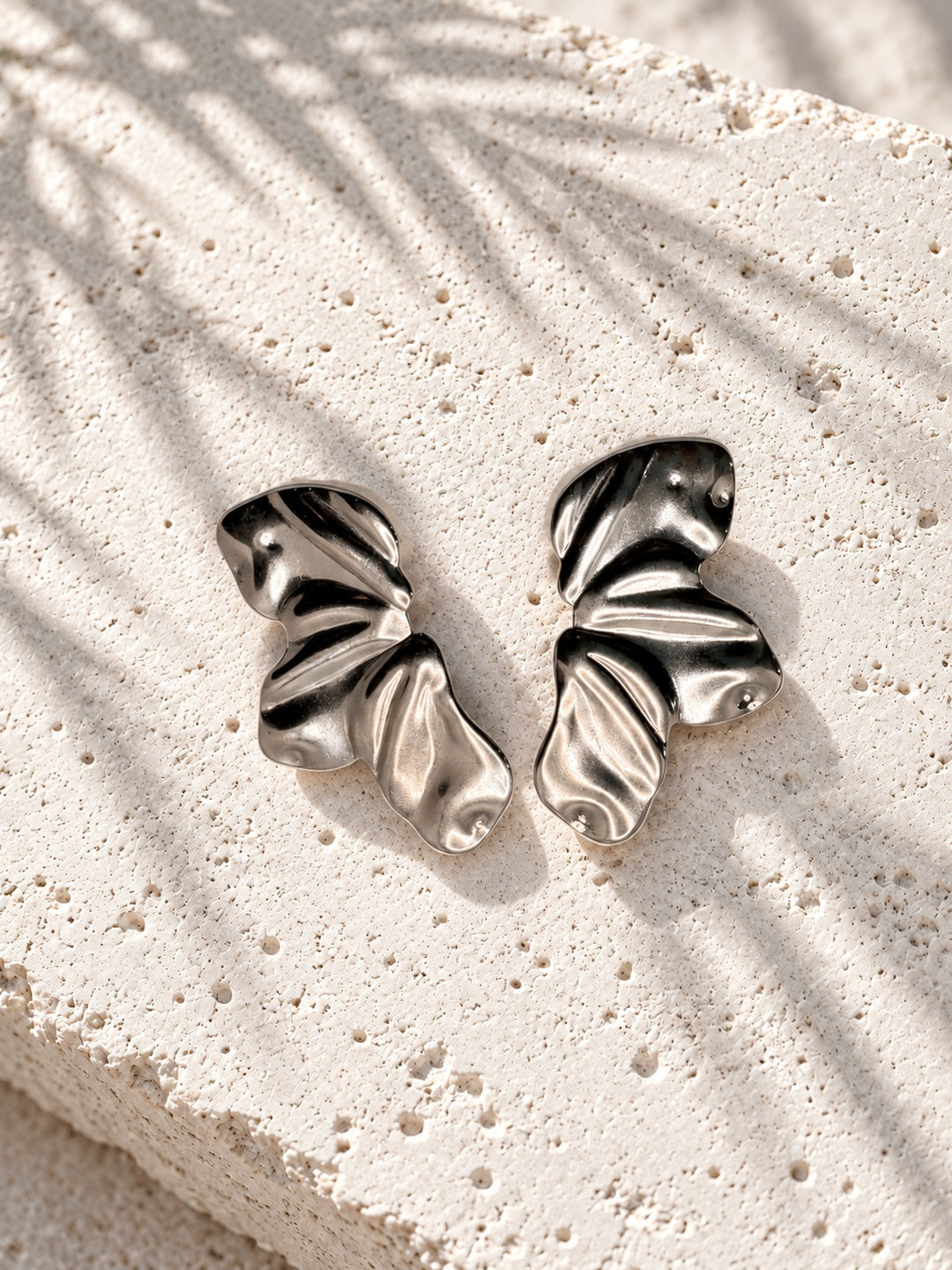Silver-tone wave earrings angled front view