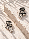 Niska statement earrings on raised white travertine slab