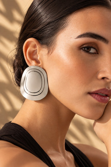Close-up model image wearing silver concentric oval earring