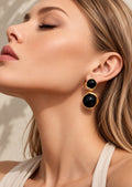 Model wearing black double sphere gold-tone drop earrings