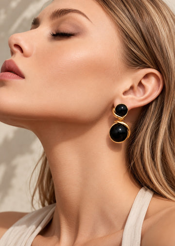 Model wearing black double sphere gold-tone drop earrings
