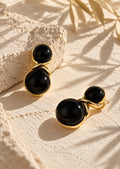 Angled view of black and gold statement earrings