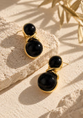 Close-up of black double sphere gold-tone earrings