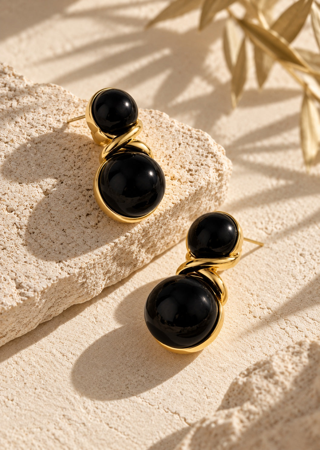 Close-up of black double sphere gold-tone earrings
