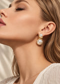 Close-up model wearing white pearl drop earrings