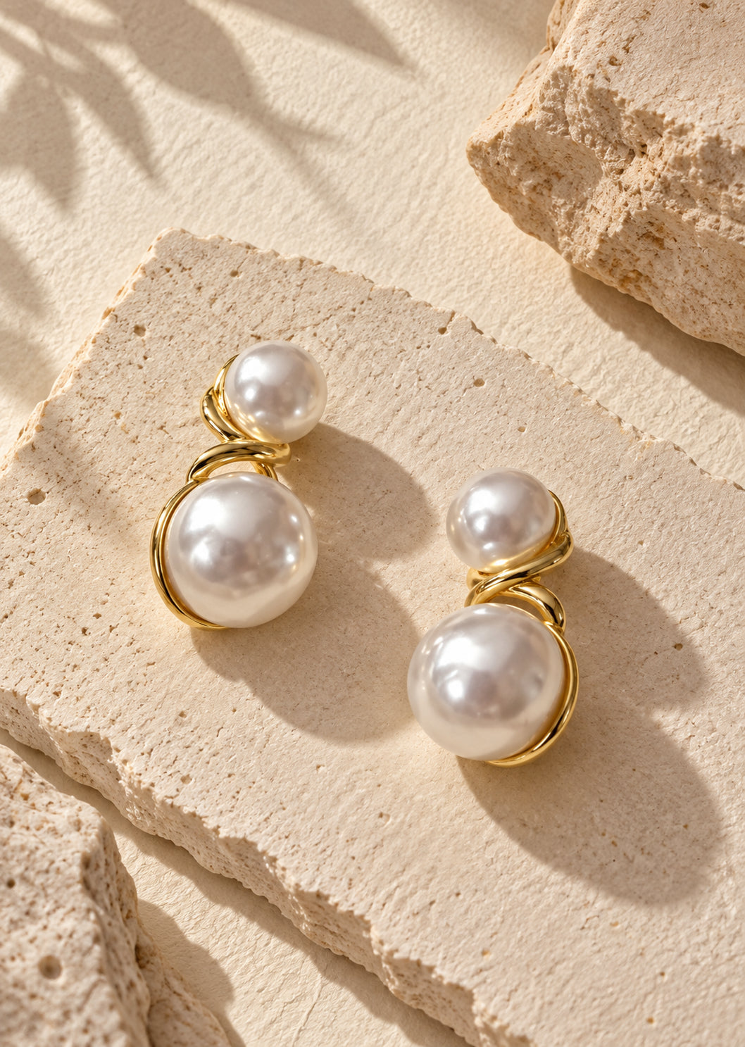 White pearl double-sphere earrings on neutral textured backdrop