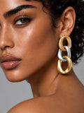 Niska gold and silver Resin link drop earrings worn with short curly hair