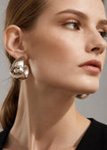 Model wearing silver hammered hoop earrings
