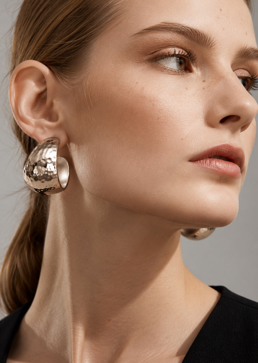 Model wearing silver hammered hoop earrings
