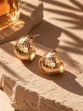 Gold earrings styled in warm sunlight