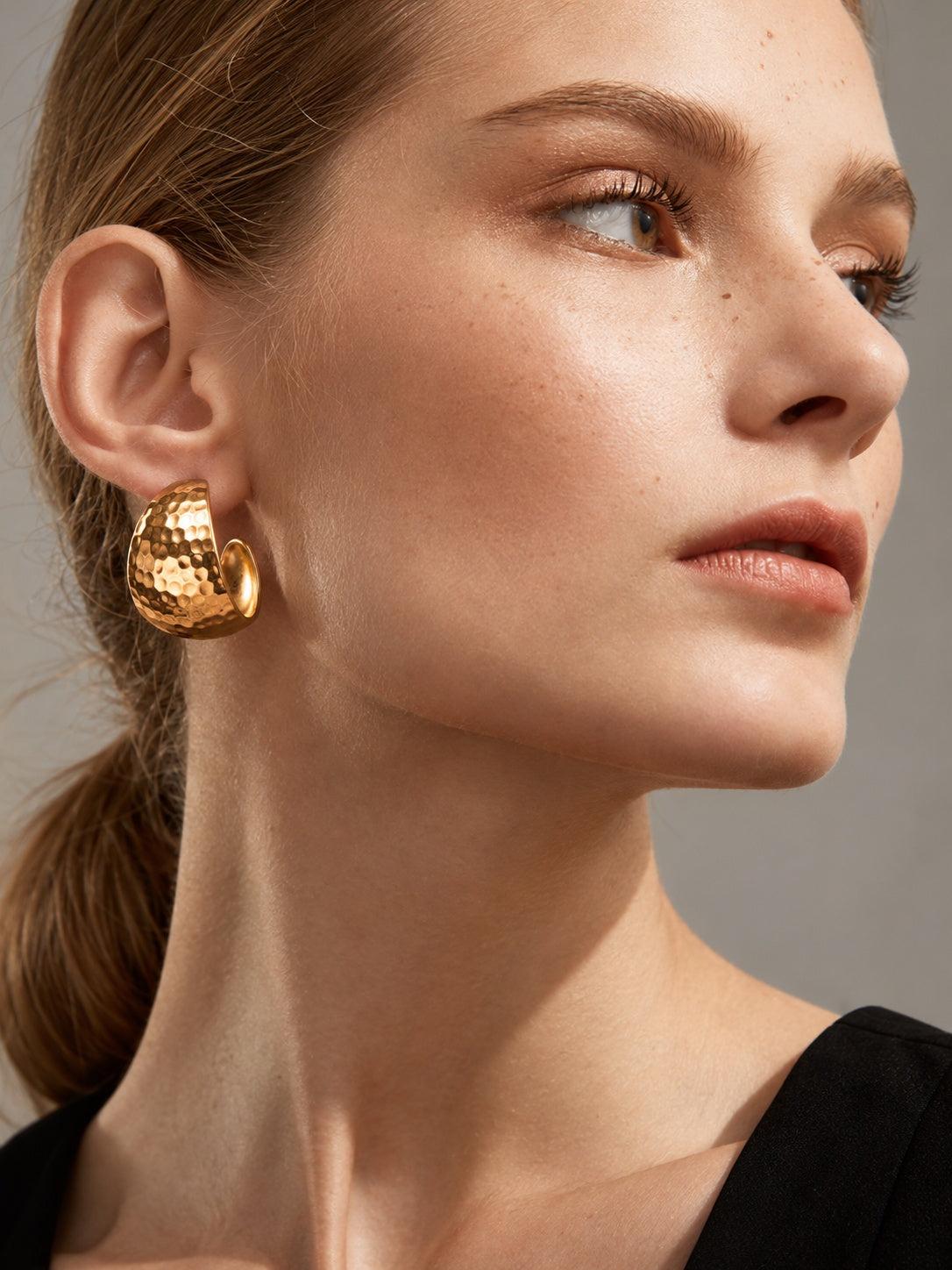 Close-up model image wearing gold earrings