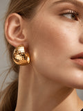 Model close-up wearing hammered gold earrings