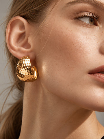 Model close-up wearing hammered gold earrings