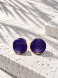 Niska purple spiral statement stud earrings on white travertine