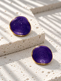 Niska purple spiral statement stud earrings on white travertine