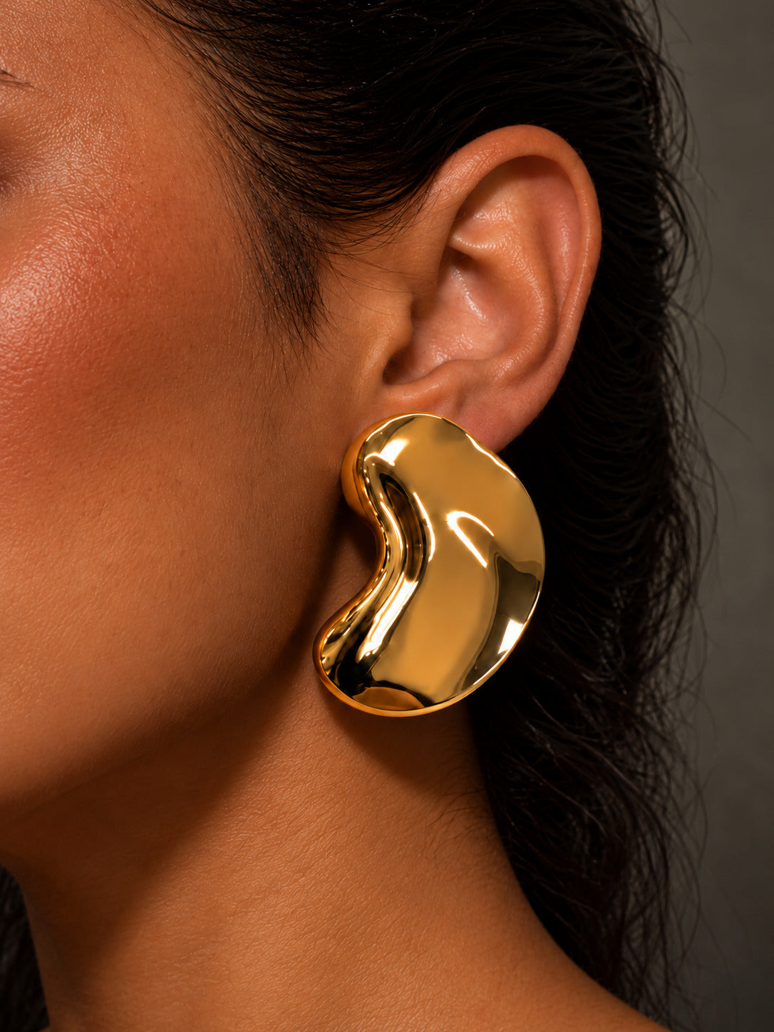 Gold tone sculptural curved statement earrings