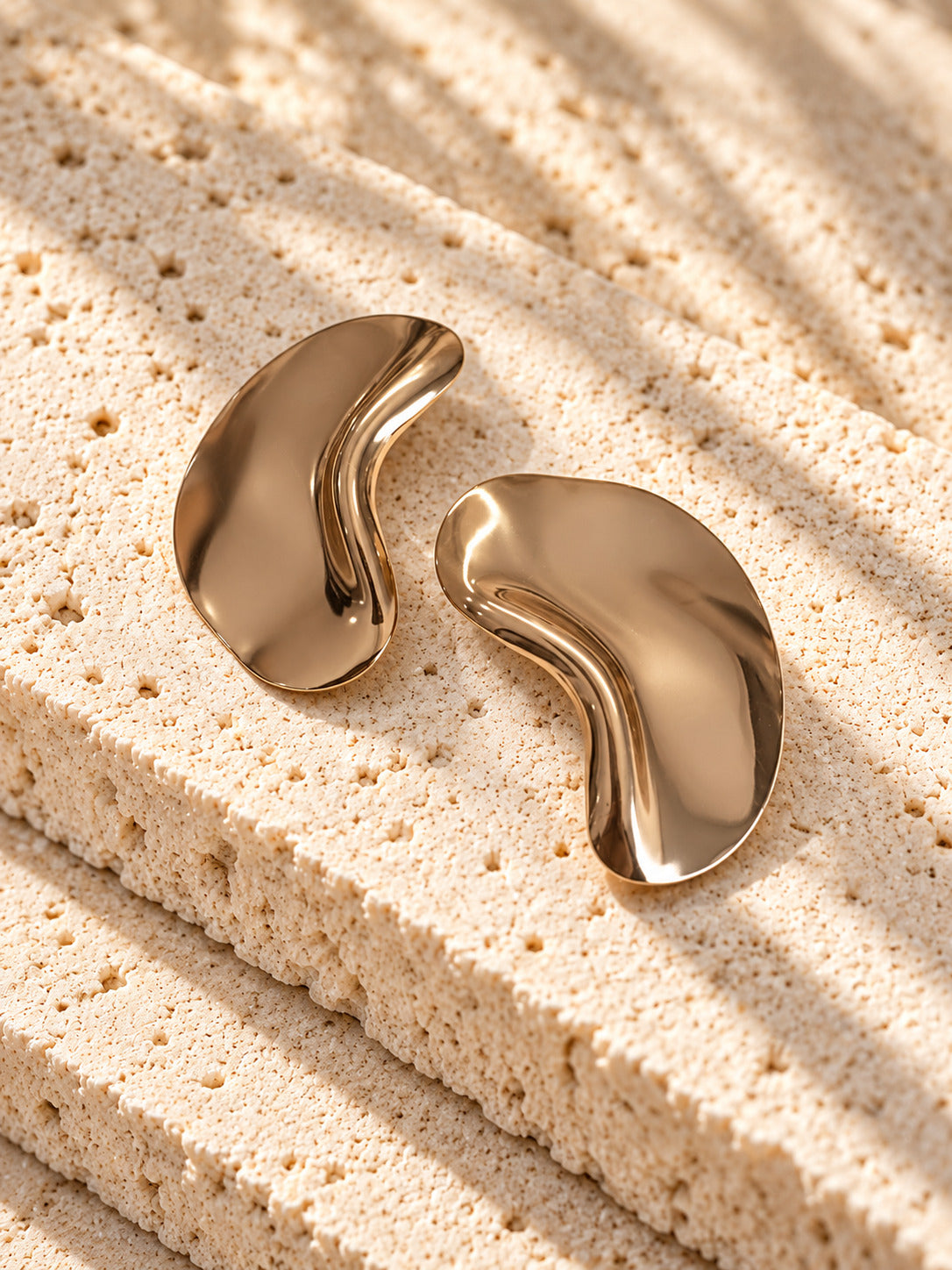Gold tone sculptural curved statement earrings