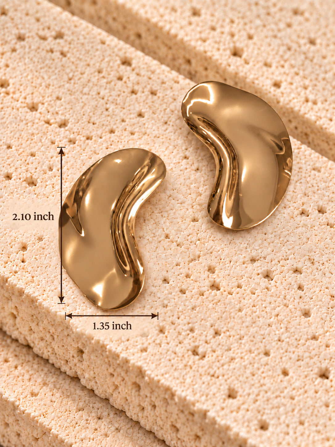 Gold tone curved earrings measuring 2.10 inch long and 1.35 inch wide