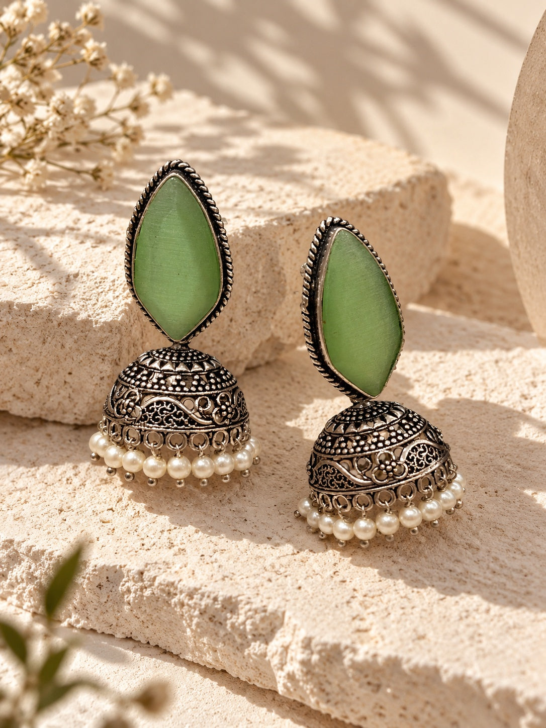 Close-up model wearing Monalisa green stone oxidized jhumka earrings