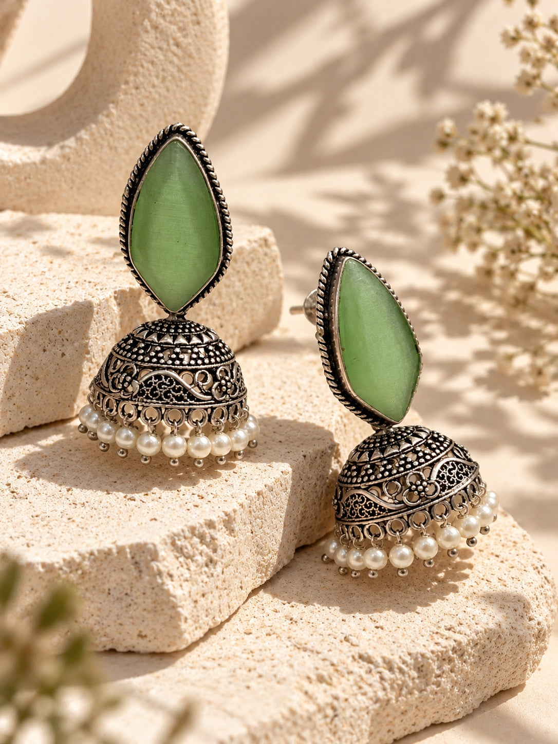 Monalisa green stone oxidized jhumka earrings angled view