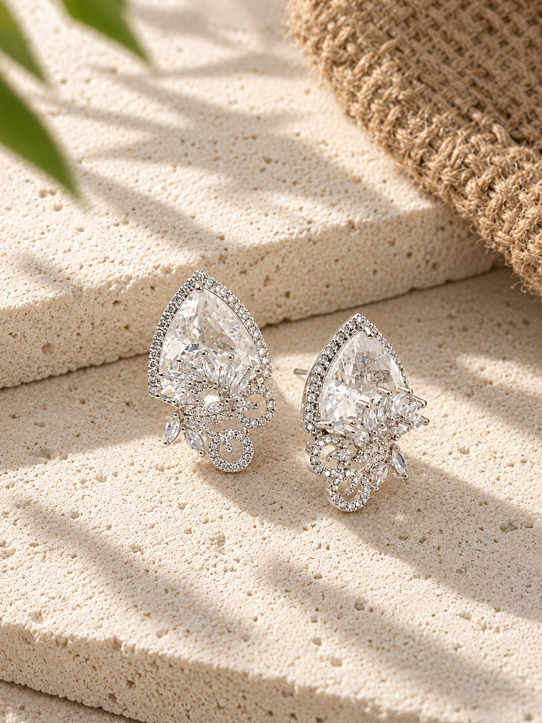 Pair of silver replica AD stone earrings on porous travertine