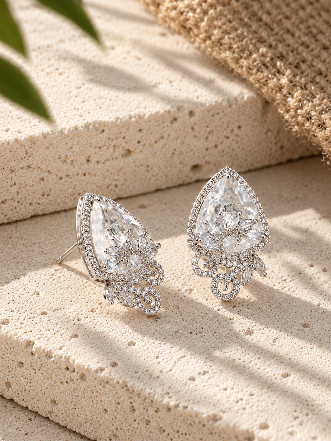 Silver replica AD stone earrings styled on textured stone