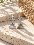 Niska AD Stone Silver Replica triangular drop earrings on white travertine view 1