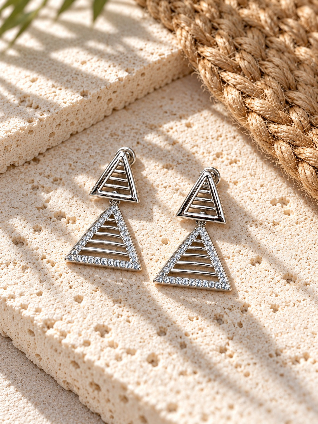 Niska AD Stone Silver Replica triangular drop earrings on white travertine view 2