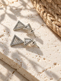 Niska AD Stone Silver Replica triangular drop earrings on white travertine view 3