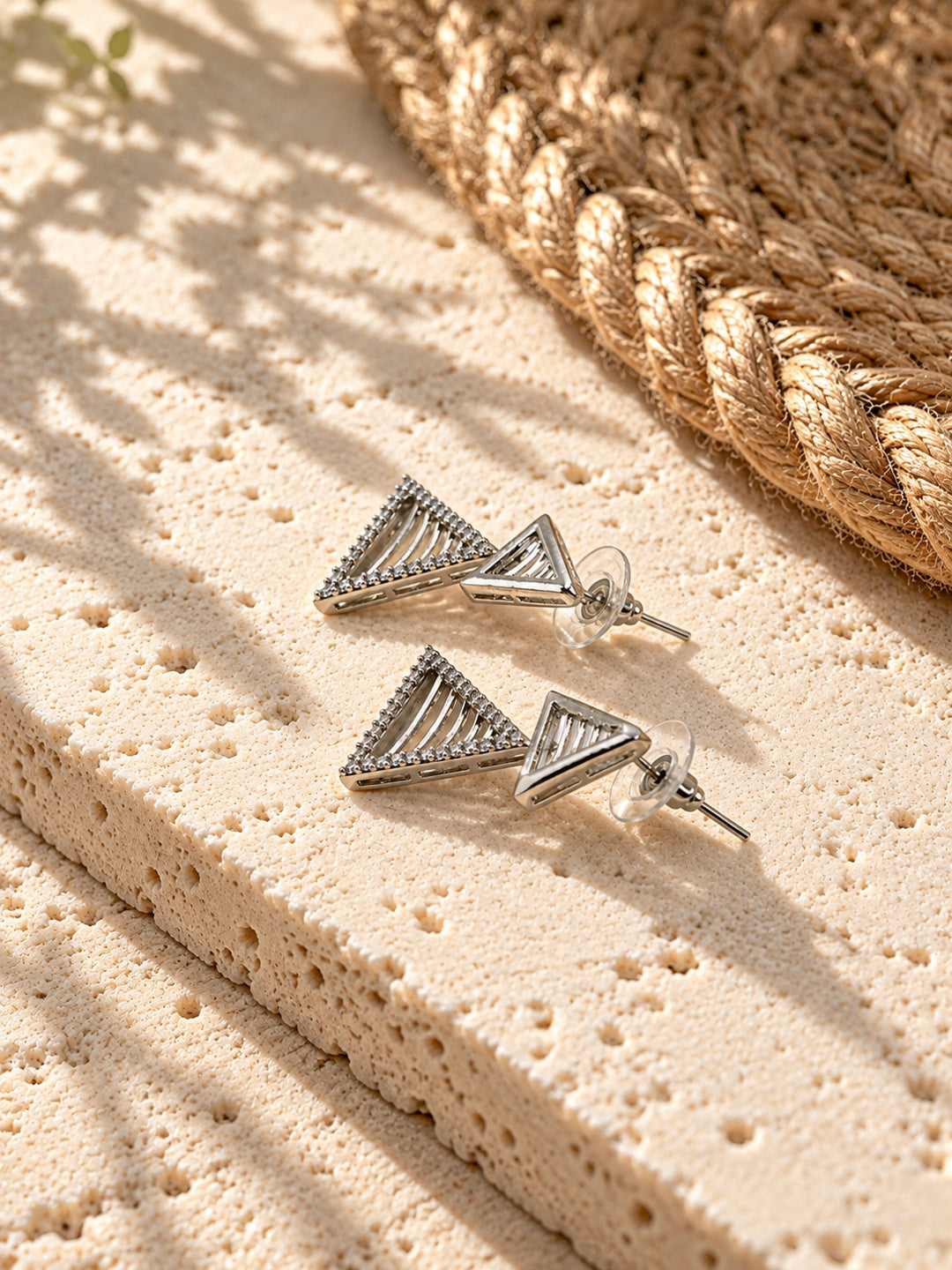 Niska AD Stone Silver Replica triangular drop earrings on white travertine view 5