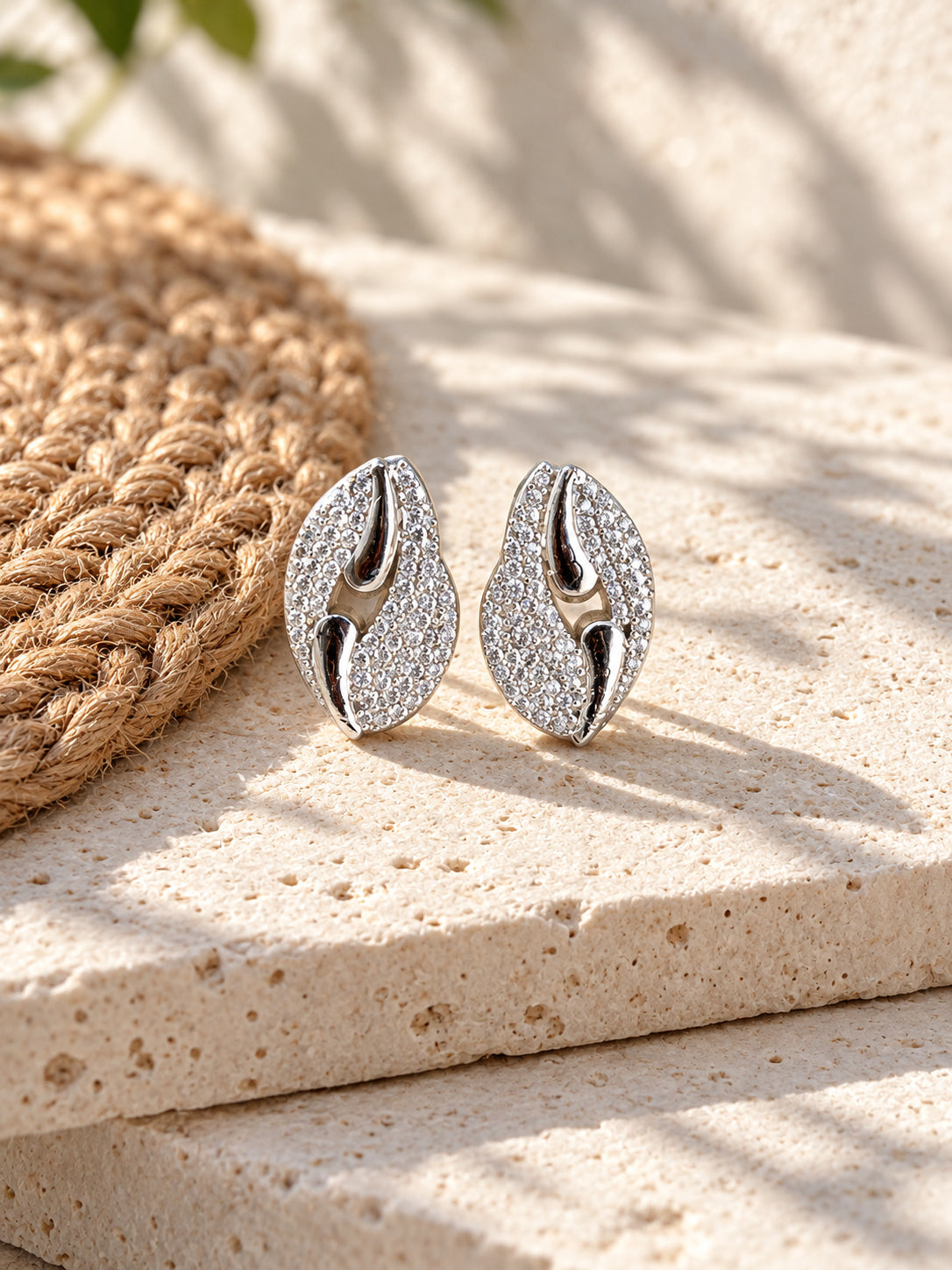 Niska Silver replica AD Stone leaf stud earrings on white travertine view 1