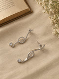 NISKA silver crystal loop drop earrings close-up editorial flat lay