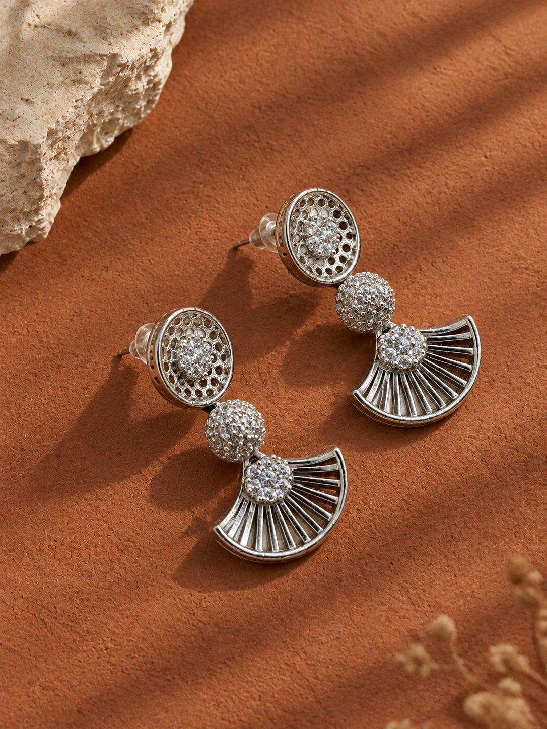 Angled view of silver fan-shaped statement earrings