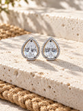 Niska AD Stone Silver Replica pear stud earrings on white travertine, view 1